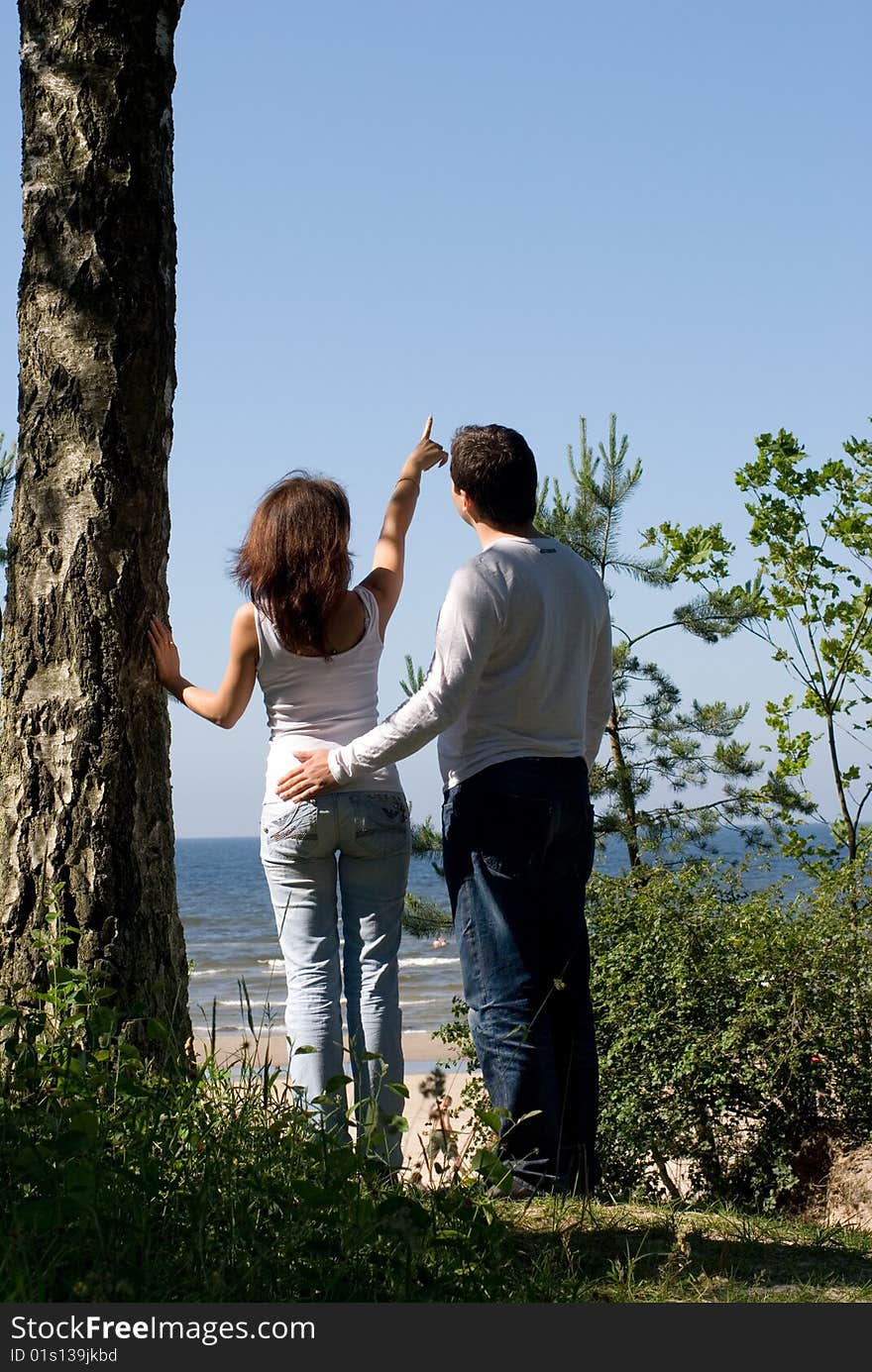 Girl and a man of the sea and pointed a hand in the sky. Girl and a man of the sea and pointed a hand in the sky