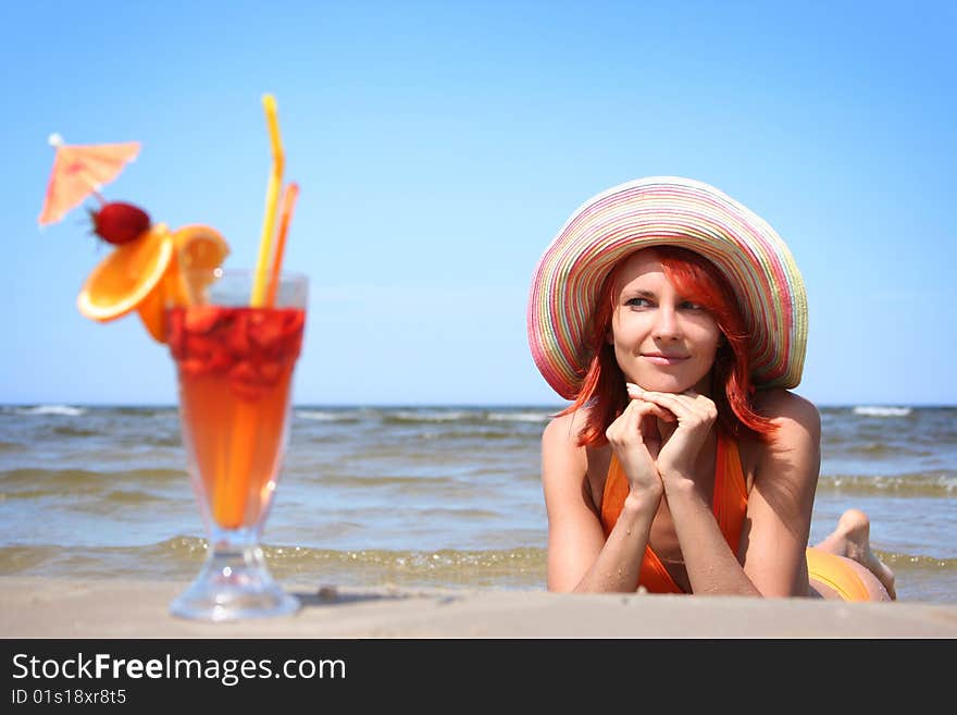 Young woman with fruit cocktail relaxing on beach. Young woman with fruit cocktail relaxing on beach