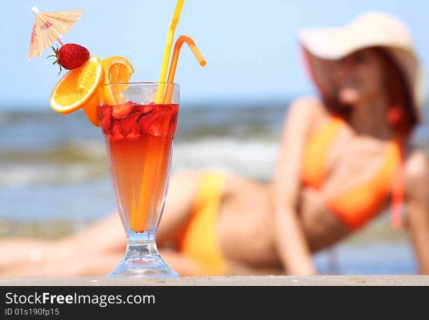 Young woman with fruit cocktail relaxing on beach. Young woman with fruit cocktail relaxing on beach