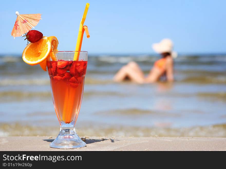 Young woman with fruit cocktail relaxing on beach. Young woman with fruit cocktail relaxing on beach