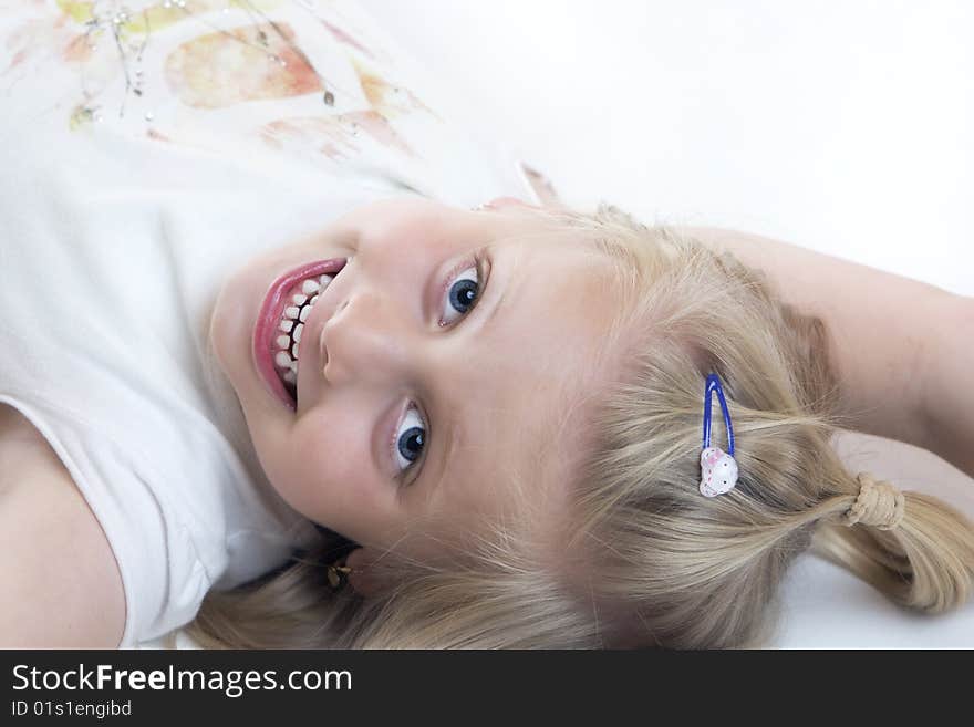 Young child lies smiling on the floor. Young child lies smiling on the floor