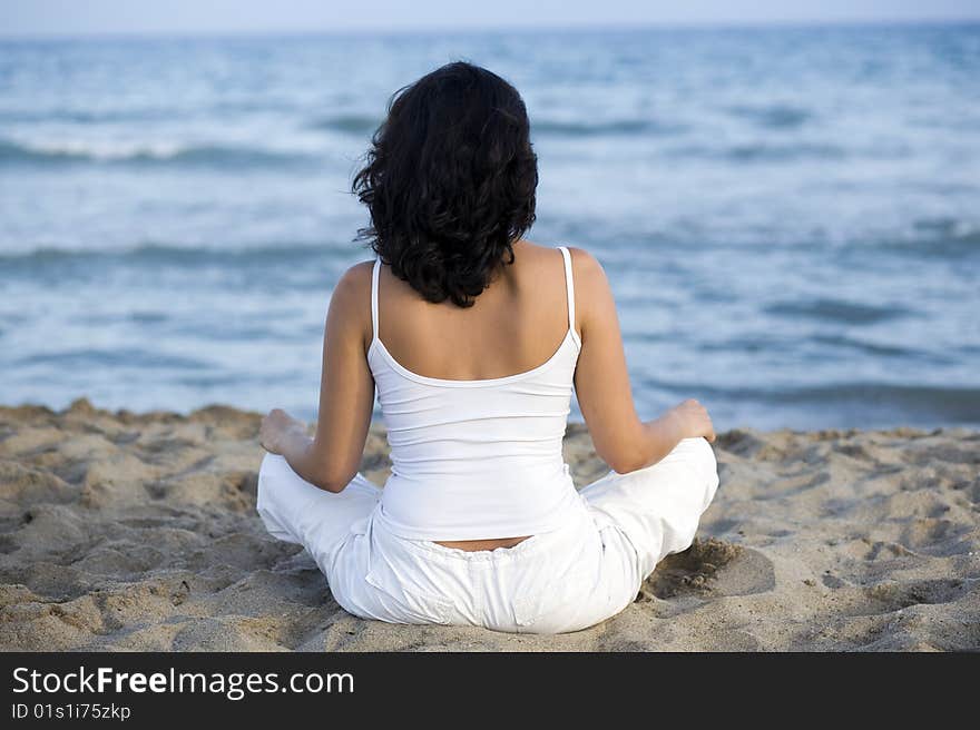 Woman making yoga exercise on the beach