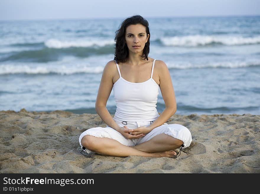 Woman Making Yoga Exercise On The Beach