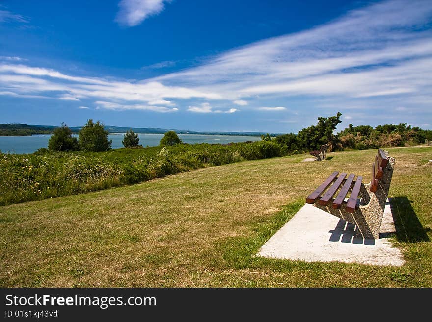 Dorset coastline of gorse, sea, sky and bench. Dorset coastline of gorse, sea, sky and bench