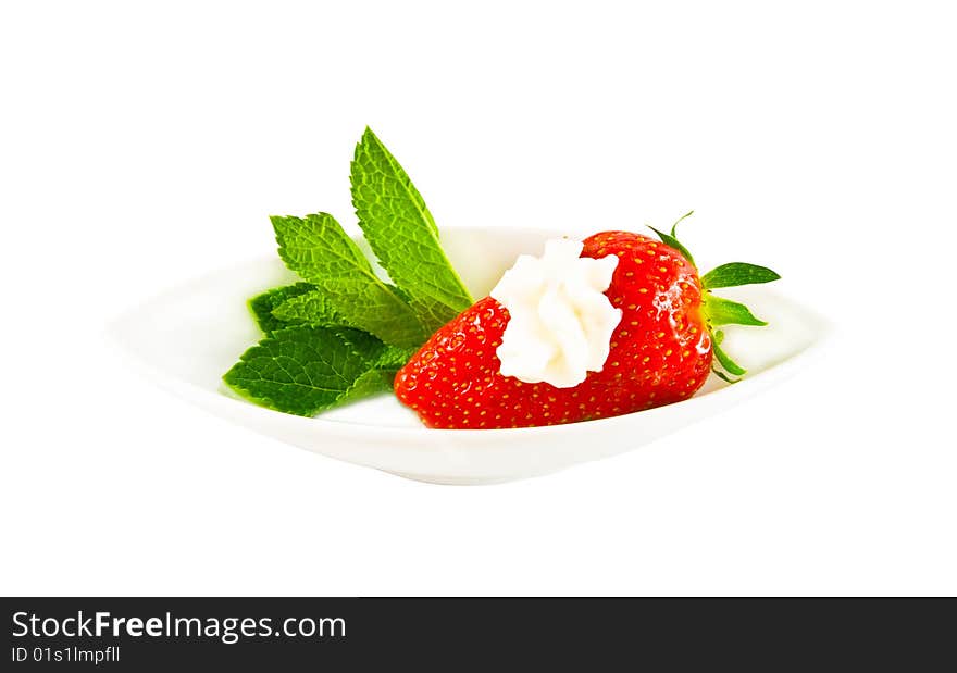 Ripe strawberry with cream on a white plate