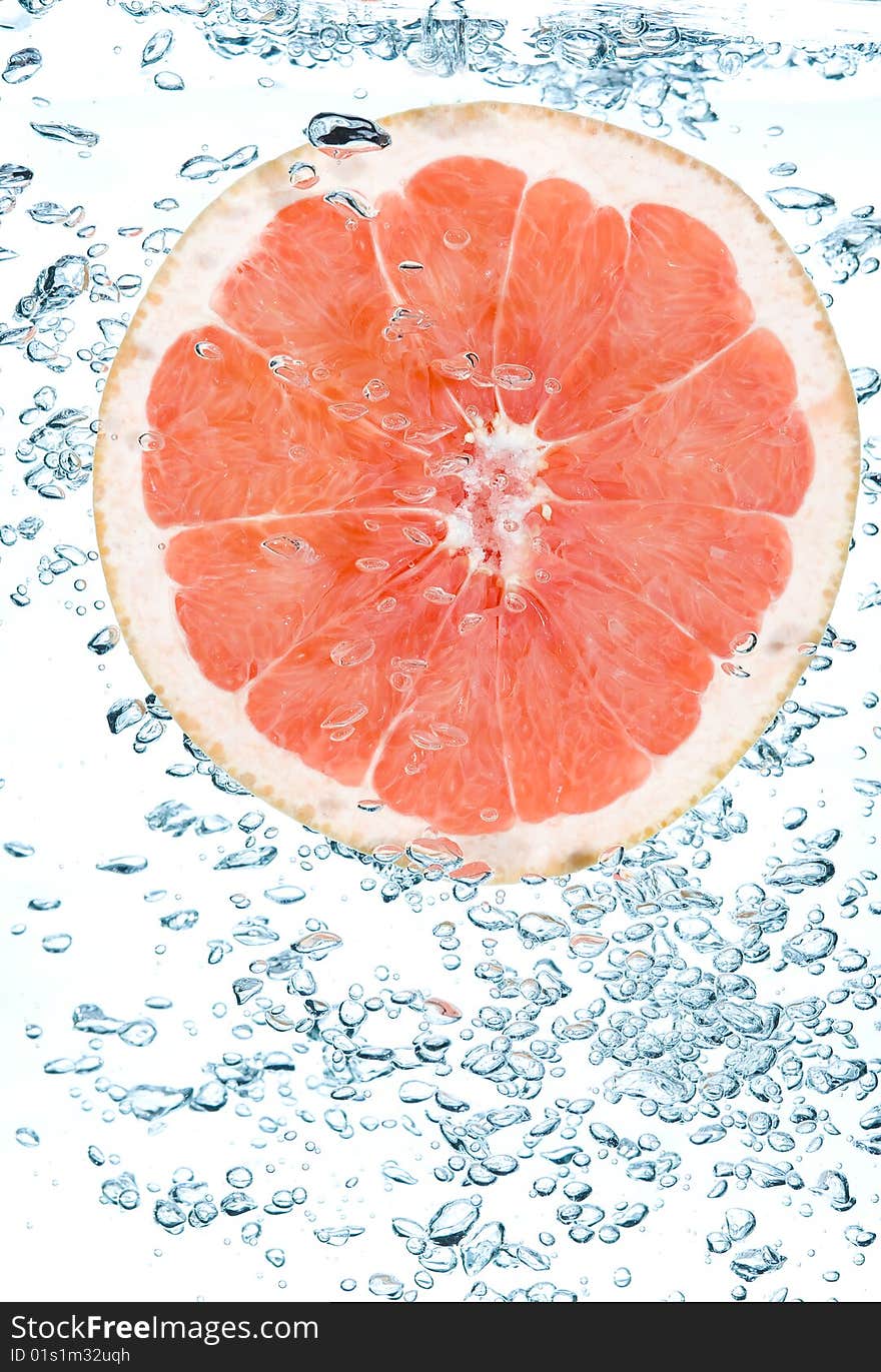 Red grapefruit in water. Creative fruit and bubbles water