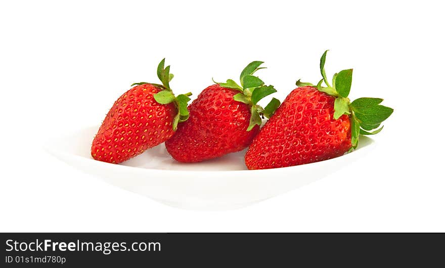 Three ripe strawberries on a white plate and a white background