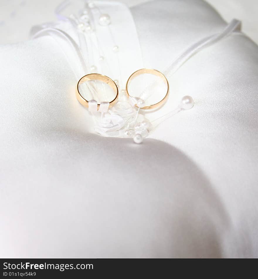 Set of wedding rings tied to a white lace pillow