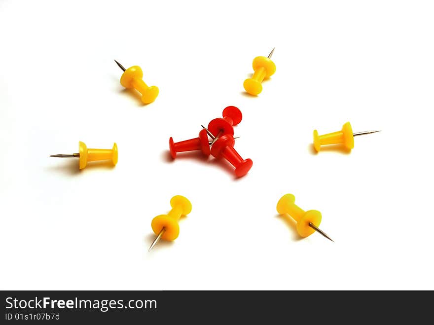 Red and yellow push pins on a white background