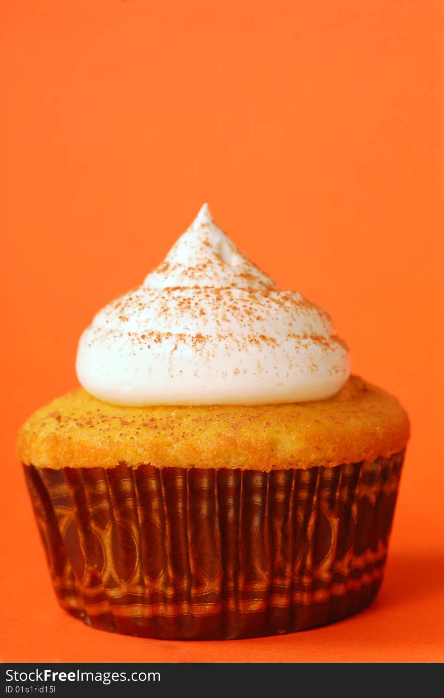 Freshly baked vanilla cupcake with meringue and powdered cocoa