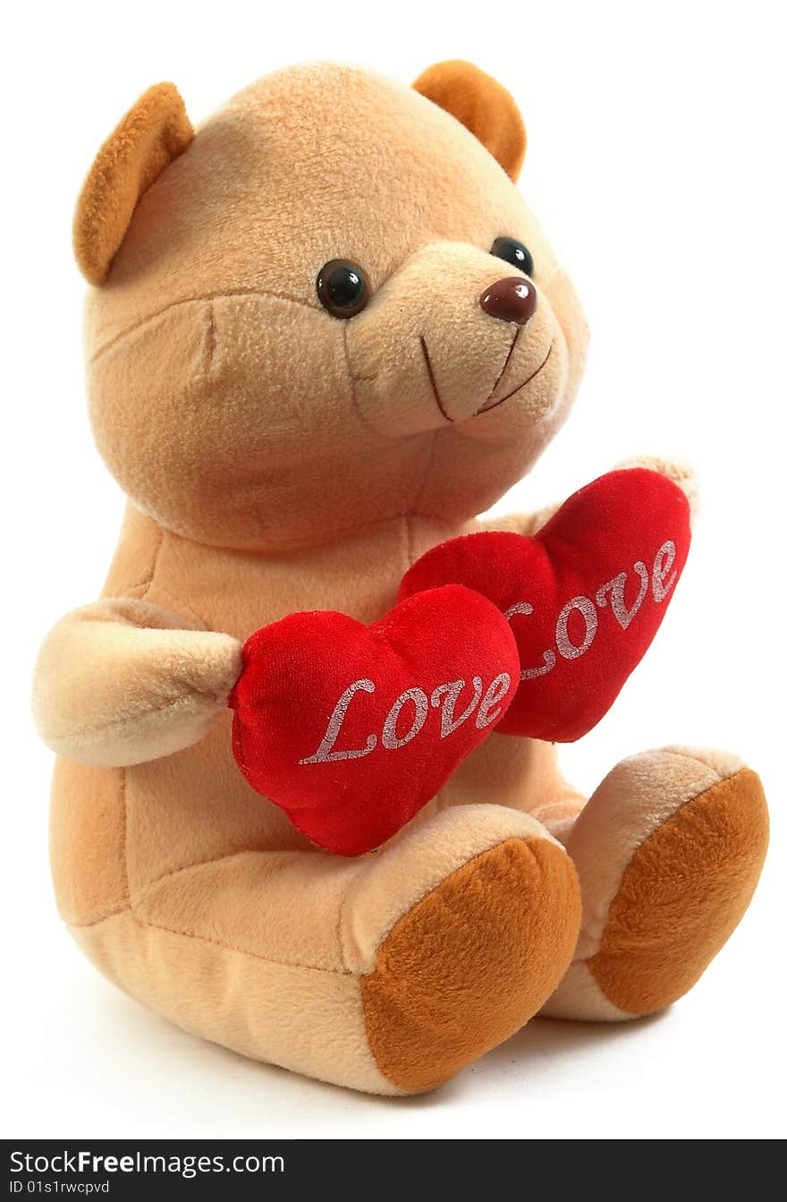 Teddy bear holding two hearts, isolated on white background.