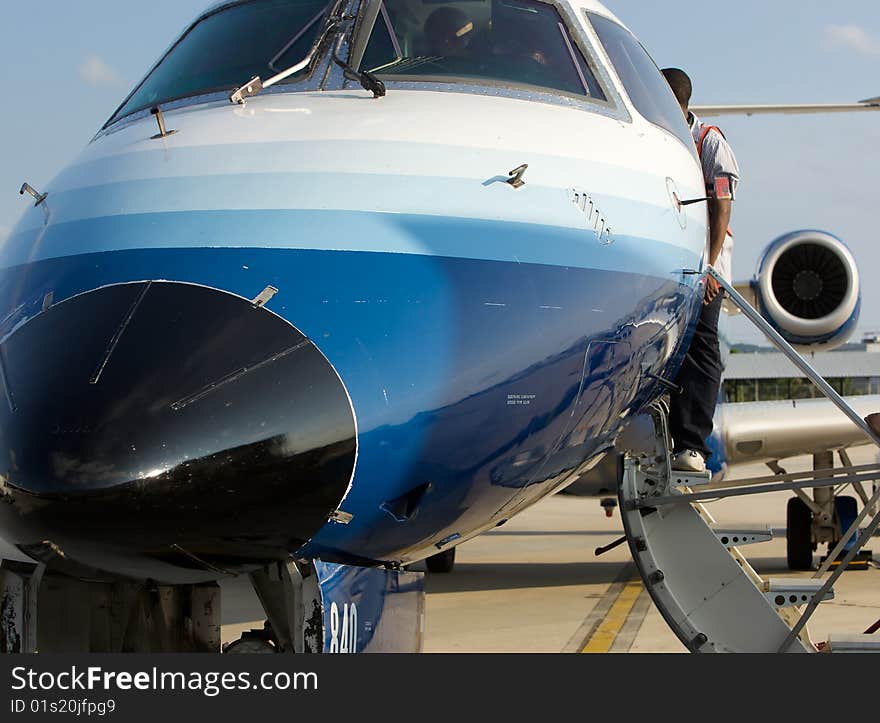 Nose view of jet airplane at airport gate preparing for departure.