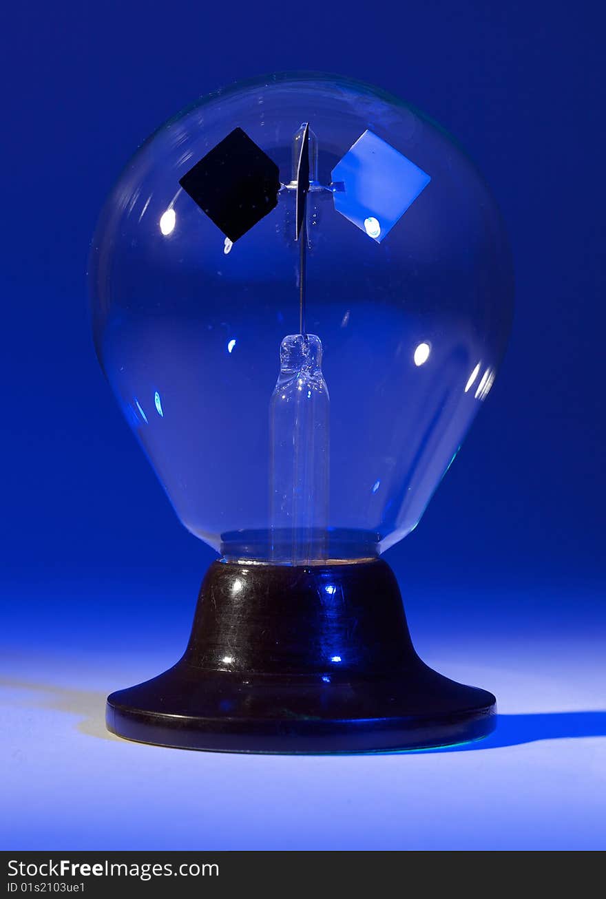 Solar spinner with blue background and spotlighted lighted base; isolated.