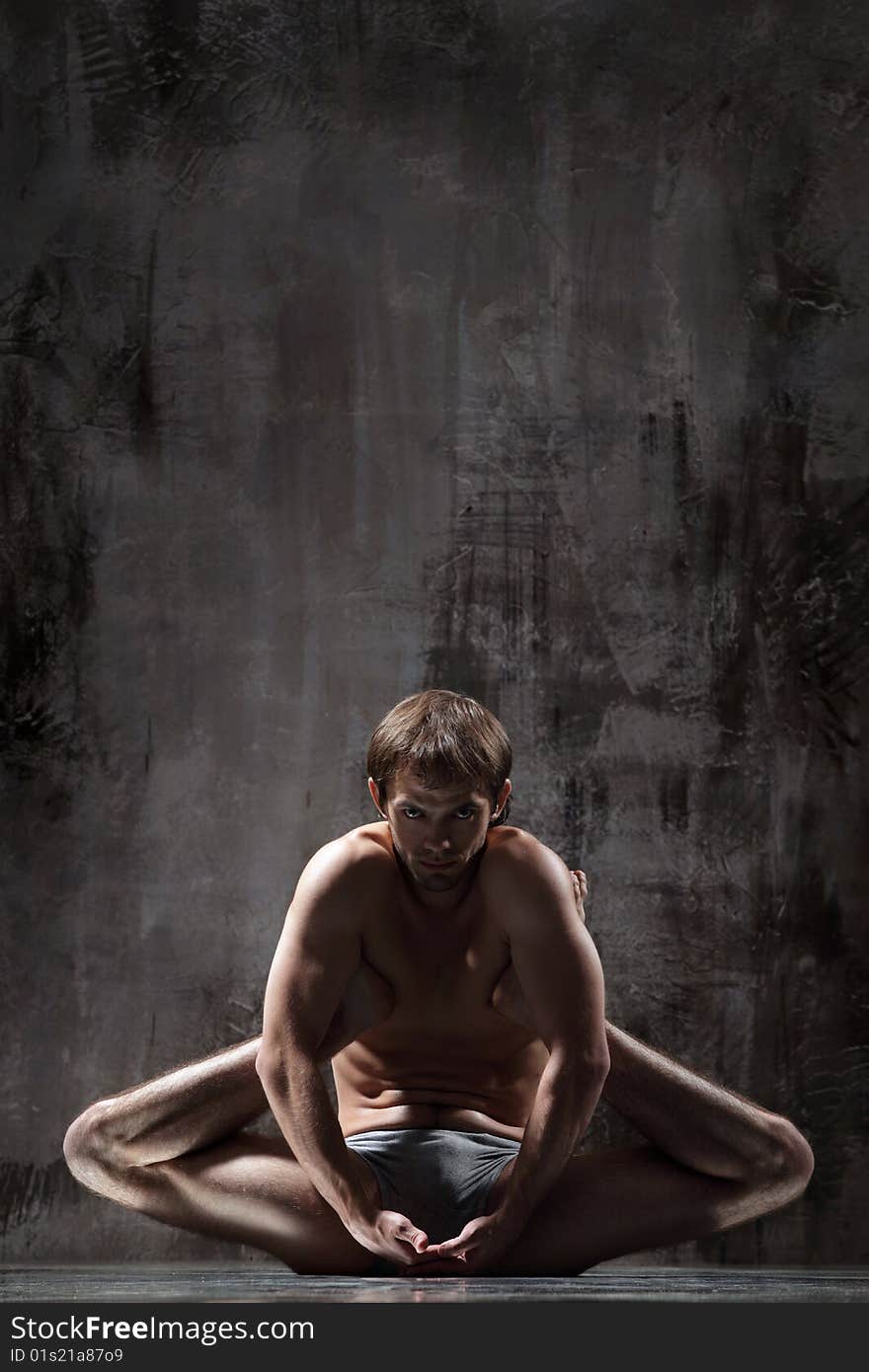 Cool yoga man posing on dirty grunge background. Cool yoga man posing on dirty grunge background