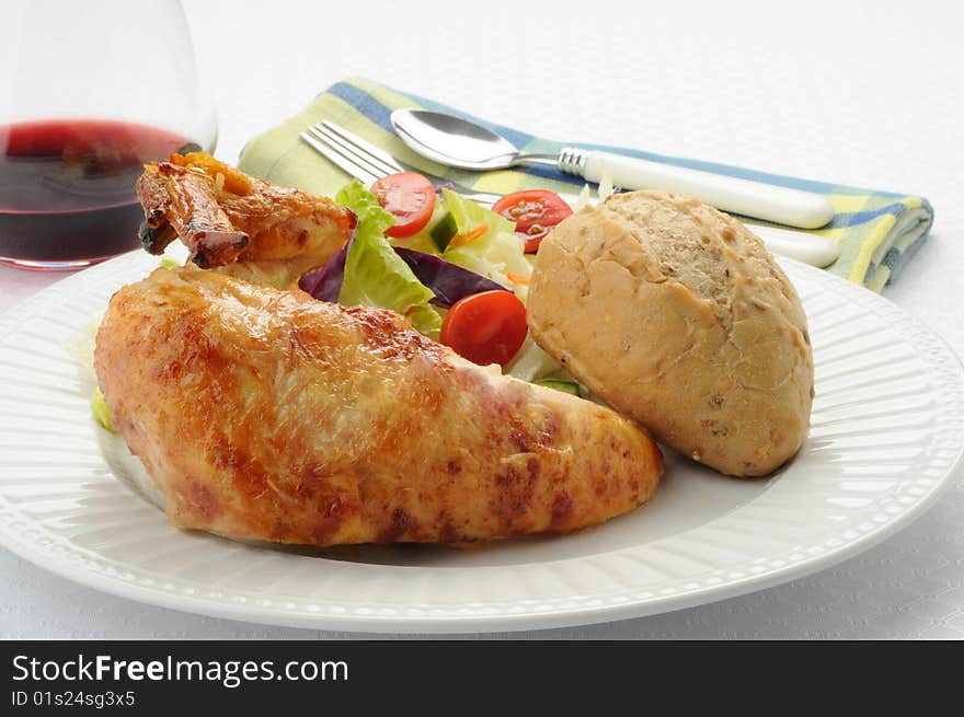 Barbecued chicken with salad and crusty roll. Barbecued chicken with salad and crusty roll.