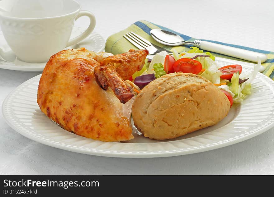 Delicious chicken served with fresh roll and salad.