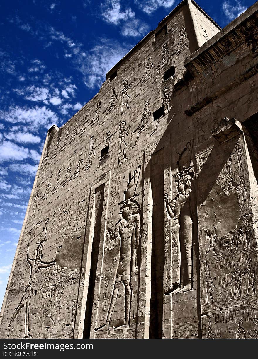 Edfu temple on the bank of the Nile river in Egypt with blue sky and clouds above