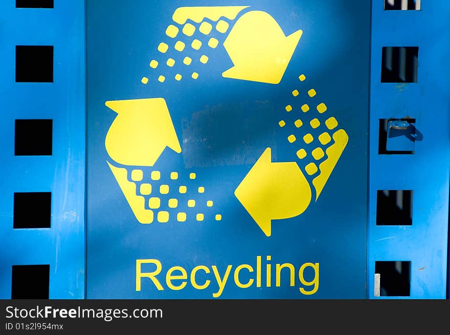 Detail of a blue and yellow recycling bin