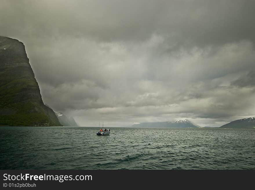 Lone motorboat, fishing on a north Norwegian fjord. Lone motorboat, fishing on a north Norwegian fjord.