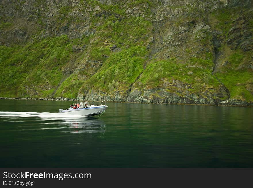 A motorboat speeding along a Norwegian fjord. A motorboat speeding along a Norwegian fjord.