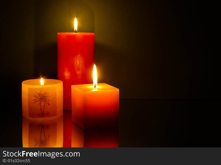 Three candles on green background