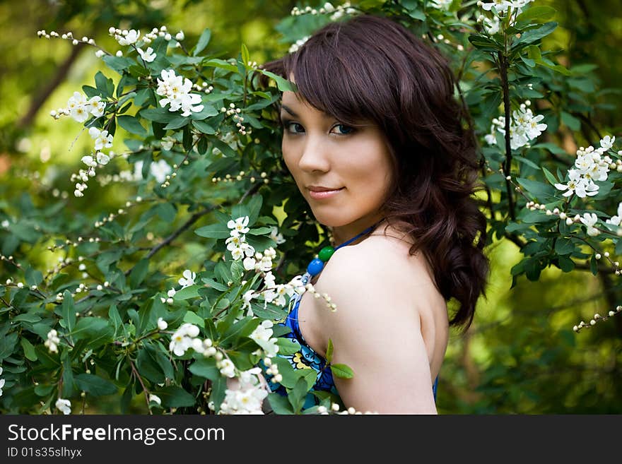 Tender girl in the garden with flowerings trees