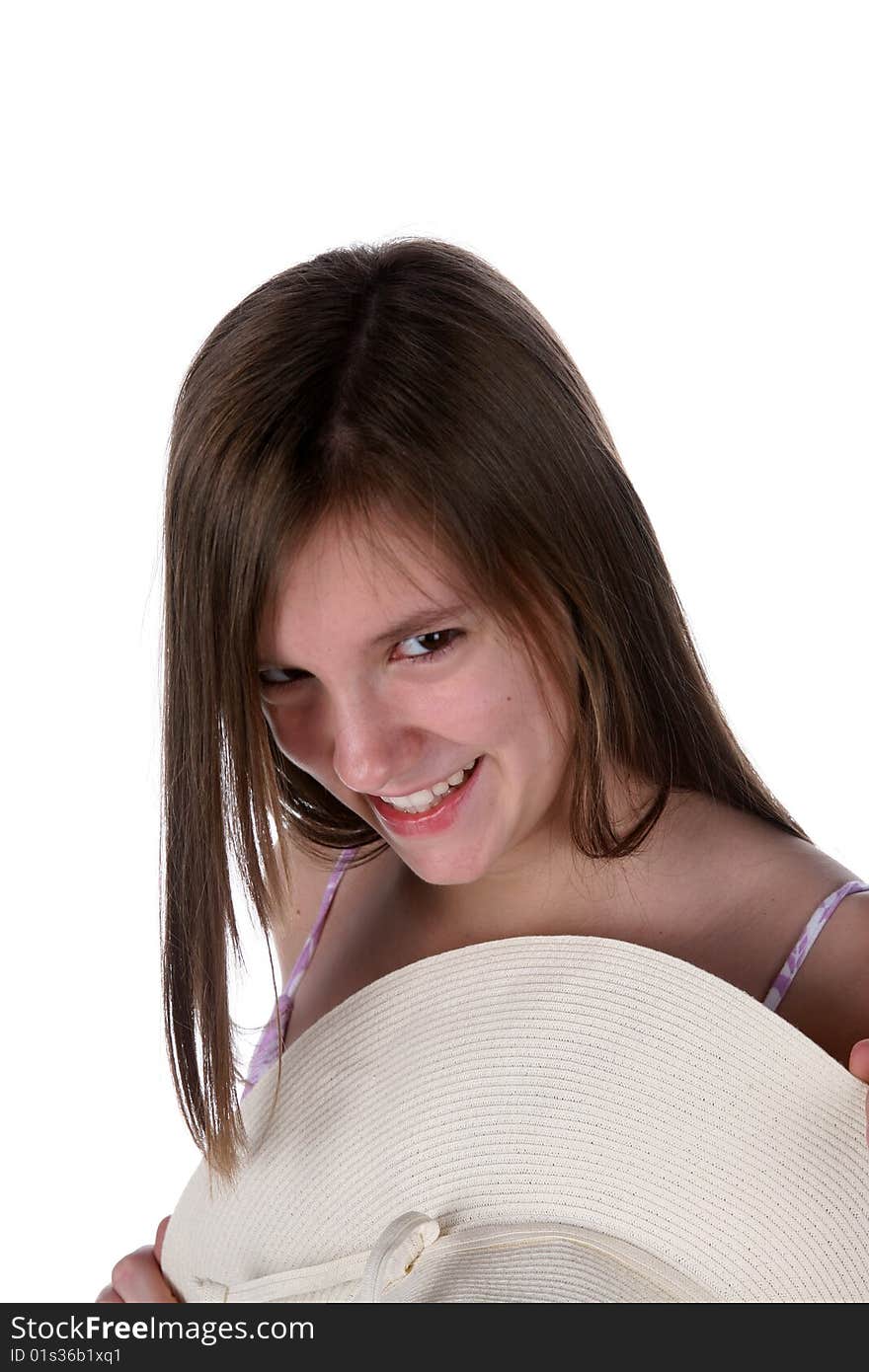 Pretty teen holding white straw hat and smiling