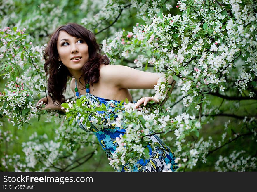 Tender girl in the garden with flowerings trees