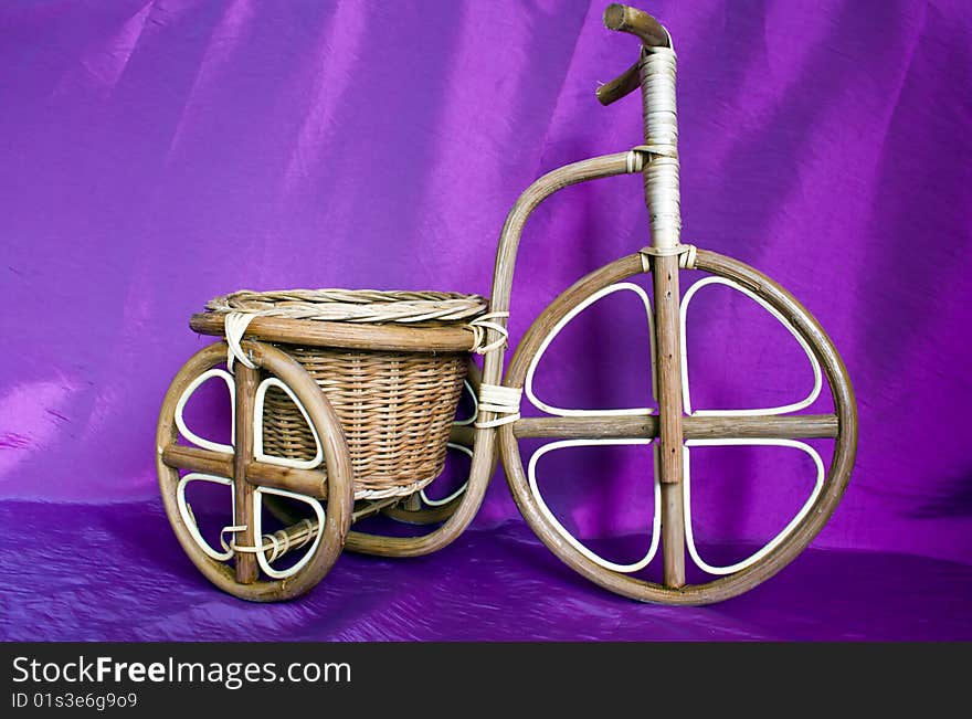 Wooden bicycle on a violet background