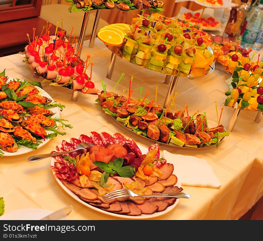 On the table are dishes of meat cutting and canapes. On the table are dishes of meat cutting and canapes