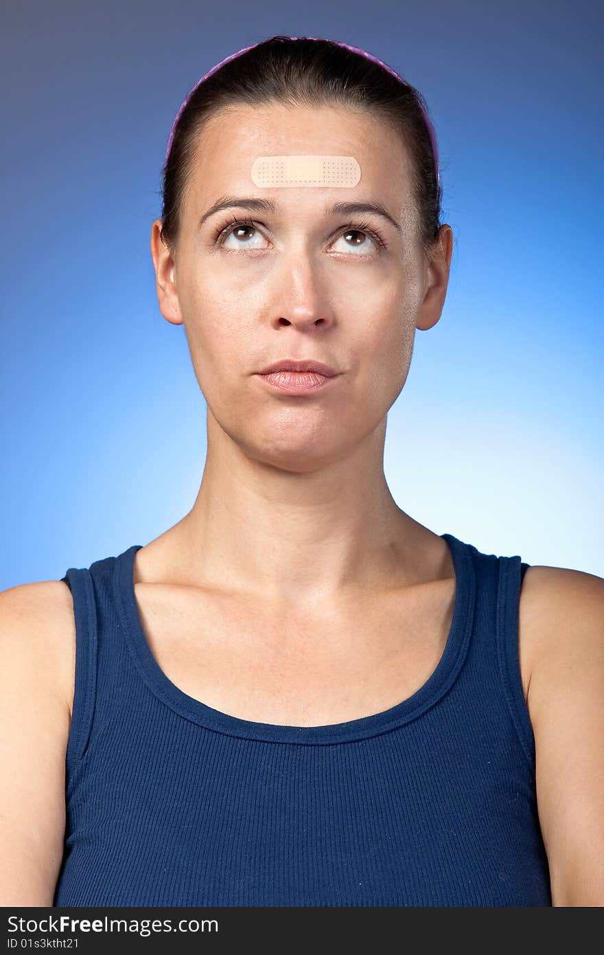 A young woman with a plaster on her face/forehead. A young woman with a plaster on her face/forehead.