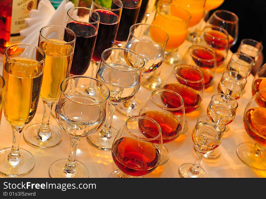 On a table stand with wine glasses, vodka, champagne and cognac. On a table stand with wine glasses, vodka, champagne and cognac