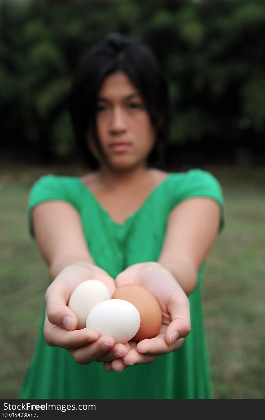 Asian girl holds chicken eggs