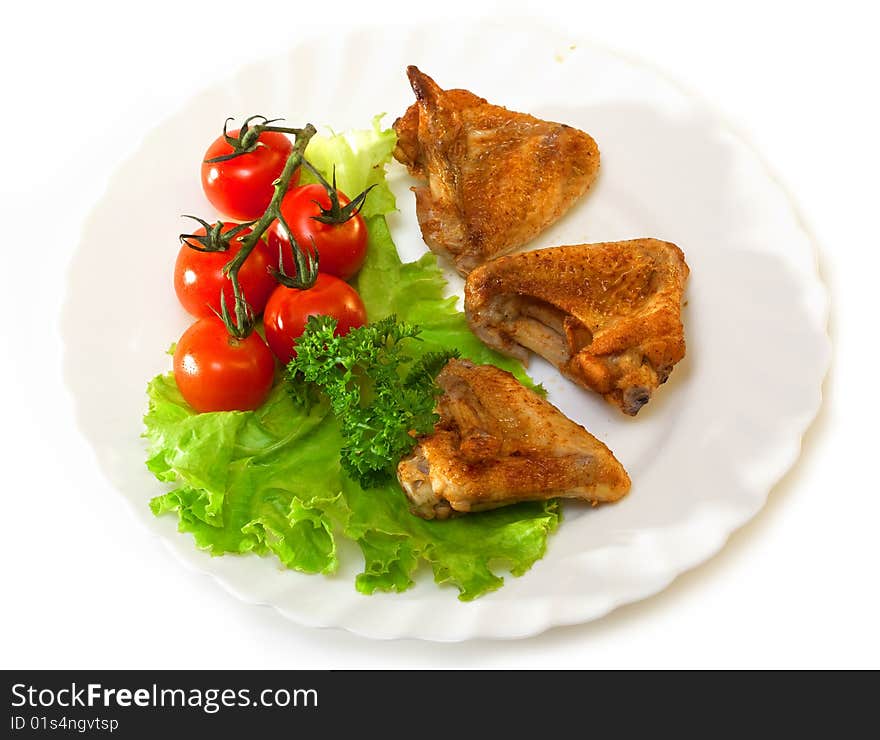 Fried chicken leg with lemon and cucumber on a plate