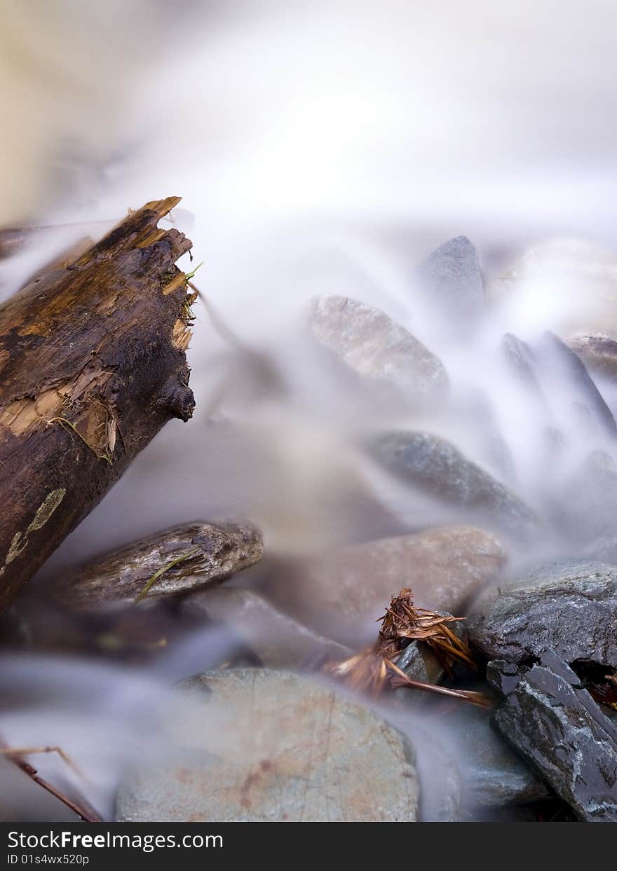 Beautiful view with flowing water. focus is on the old wood log. Beautiful view with flowing water. focus is on the old wood log.