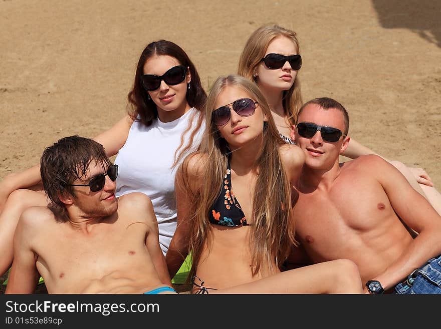 Cheerful young people having fun on a beach. Great summer holidays. Cheerful young people having fun on a beach. Great summer holidays.