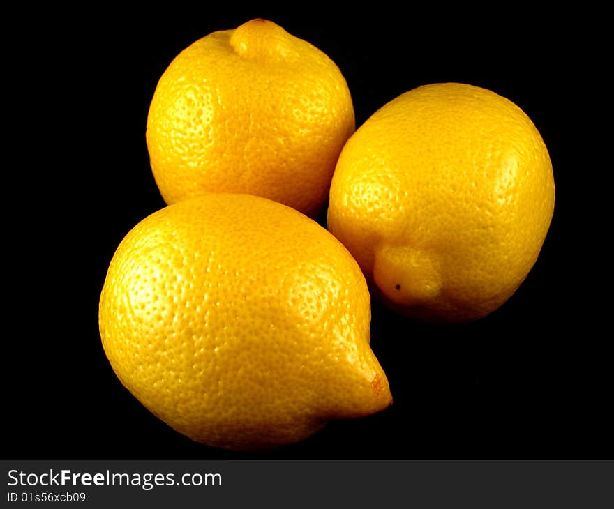 Three fresh lemons on a black background. Three fresh lemons on a black background