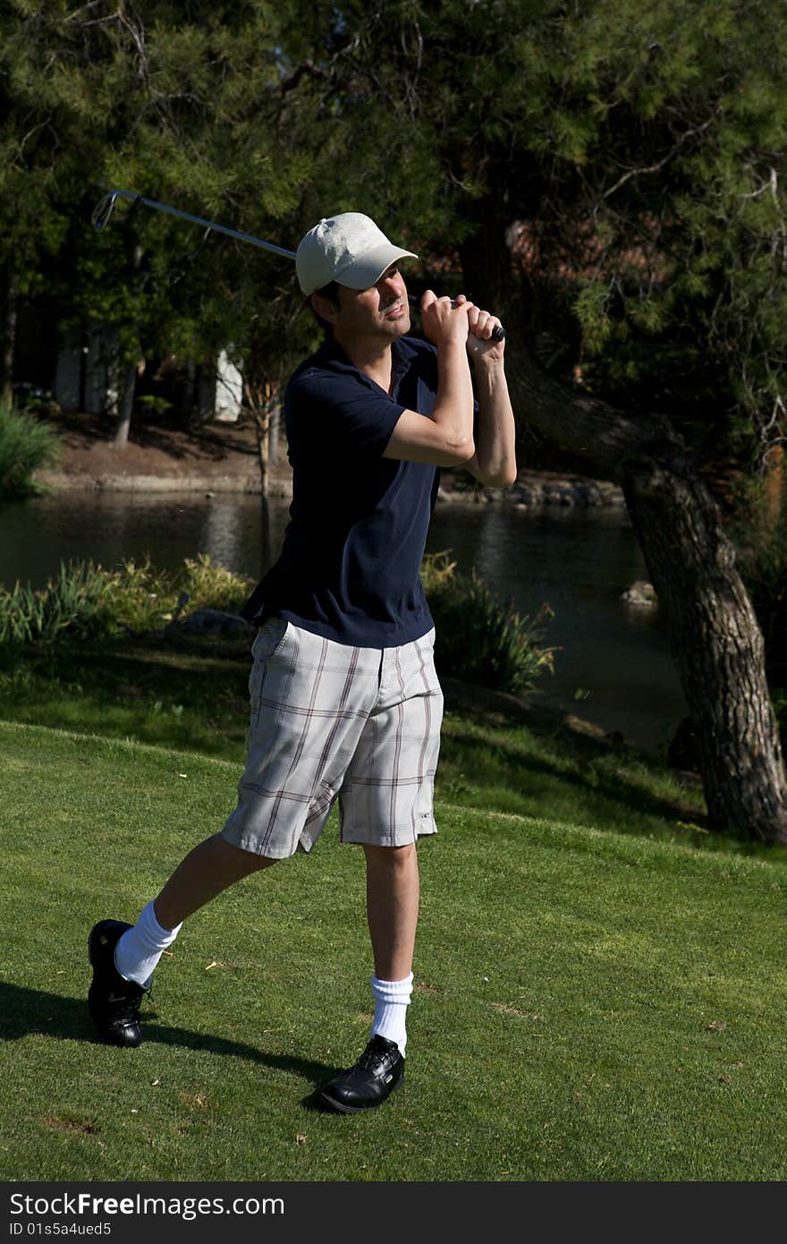 A golf player preparing to swing lining up shot. A golf player preparing to swing lining up shot