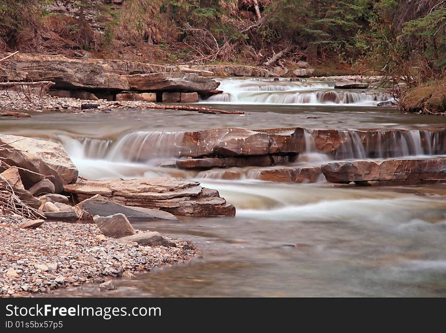 A mountain river flowing over a series of small waterfalls. A mountain river flowing over a series of small waterfalls