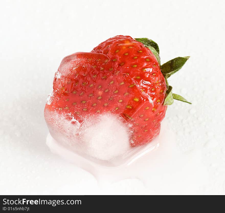 Strawberry frozen inside ice cube, melting. Shallow depth of field, selective focus. Macro shot. Extreme closeup. Strawberry frozen inside ice cube, melting. Shallow depth of field, selective focus. Macro shot. Extreme closeup.