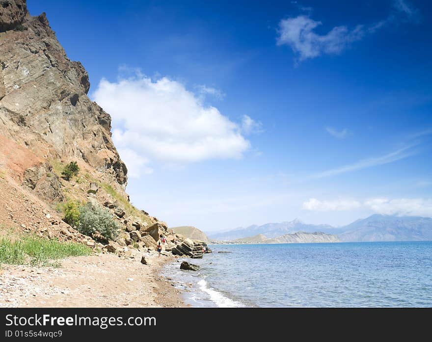 Hikers go on the sea-shore of Crimea