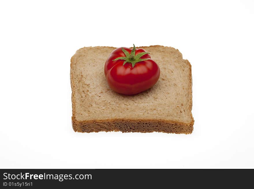 A small tomato on a slice bread for toasty of total milling. A small tomato on a slice bread for toasty of total milling