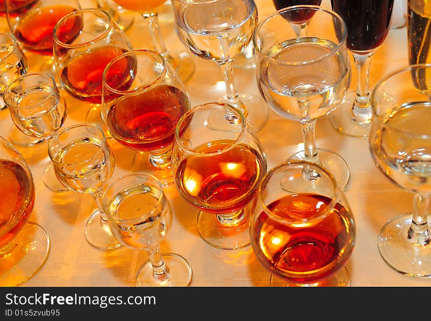 On a table stand with wine glasses, vodka, champagne and cognac. On a table stand with wine glasses, vodka, champagne and cognac