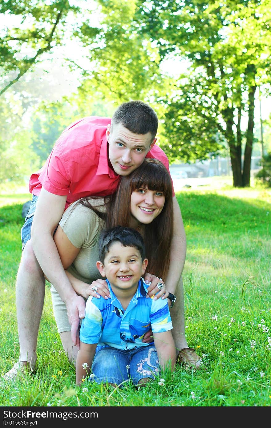 Happy young family relaxing in park. Happy young family relaxing in park