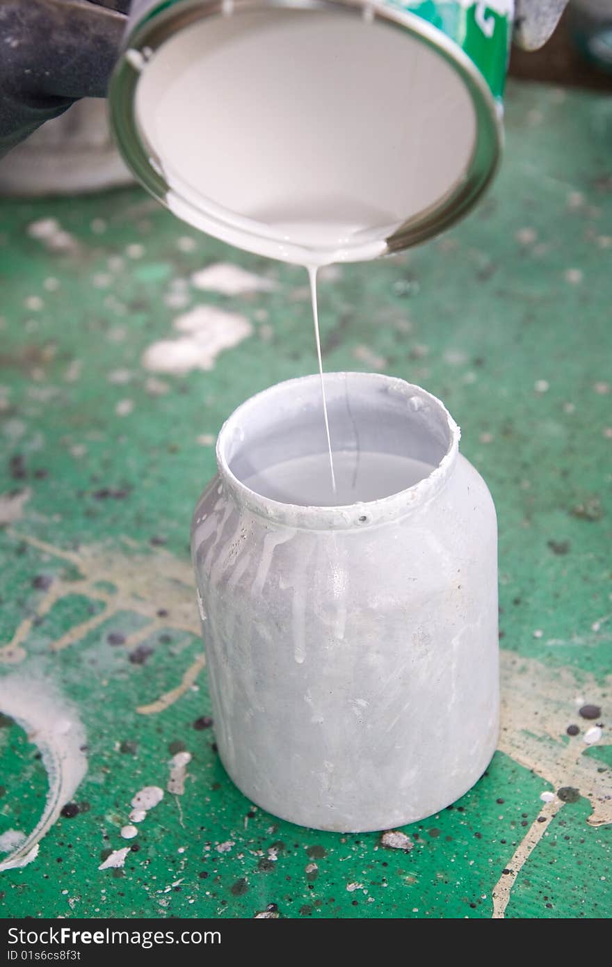 A painter mixing paint at work in his construction site