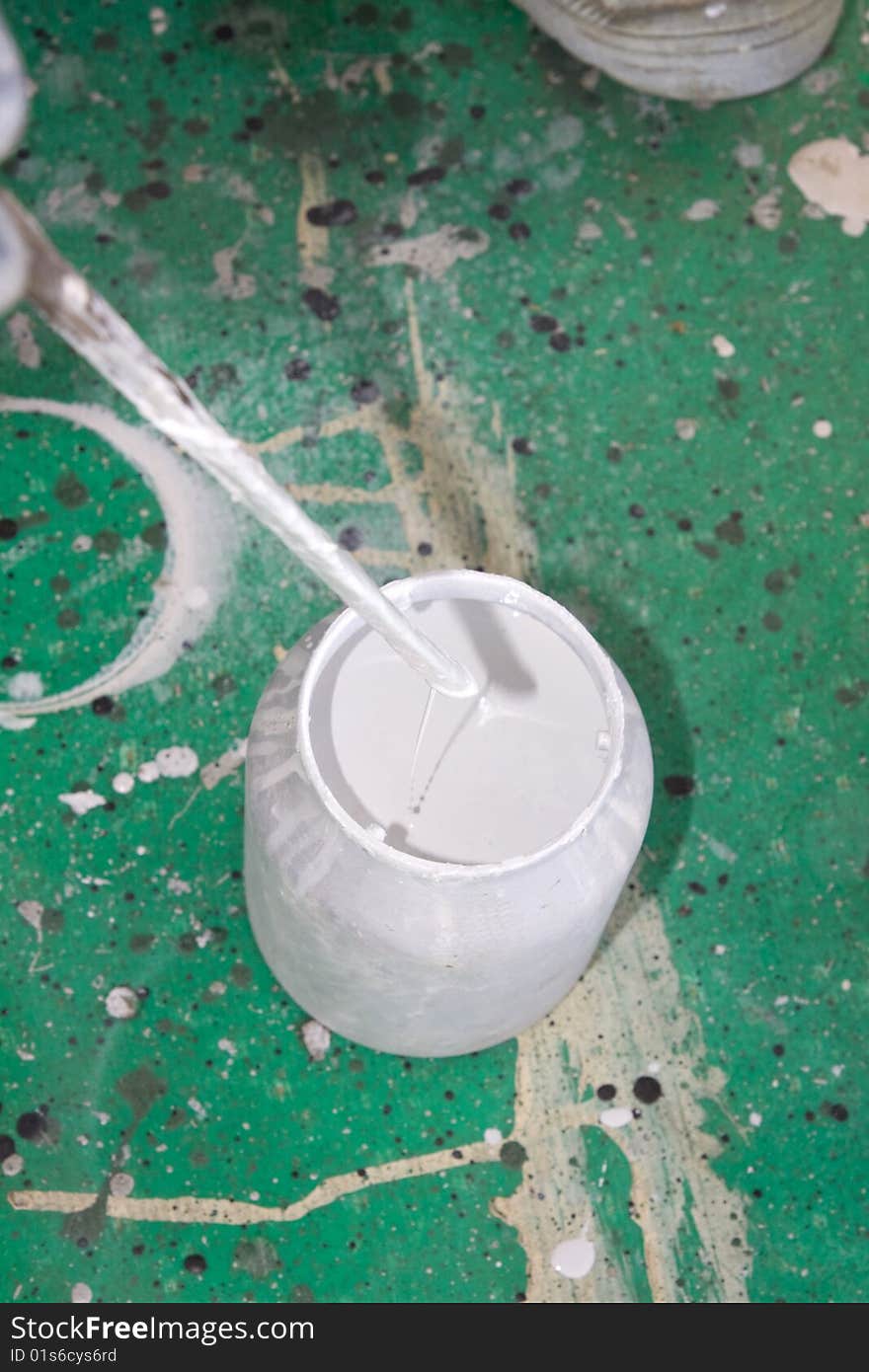 A painter mixing paint at work in his construction site