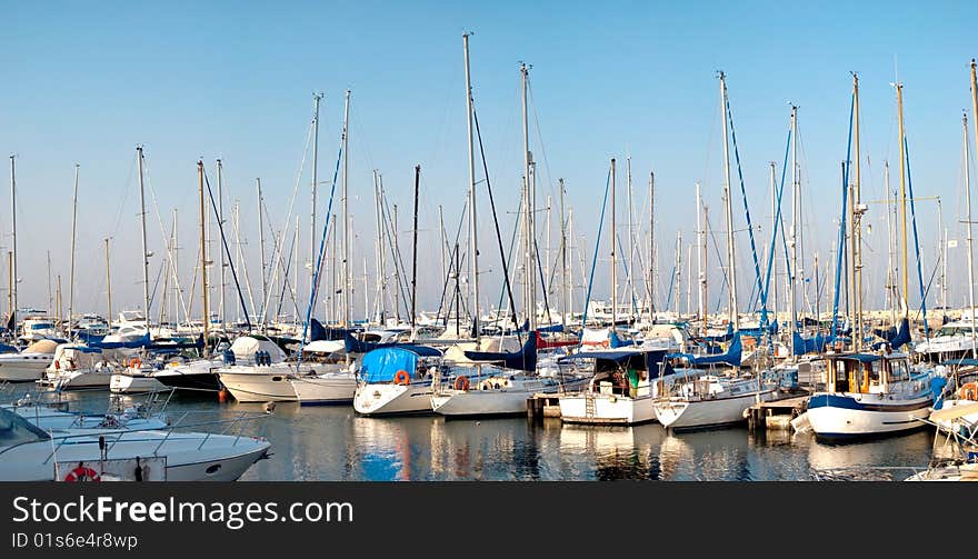 Panorama of a quiet harbor with white yachts and boats, the sunset over the island of Cyprus, a series of images. Panorama of a quiet harbor with white yachts and boats, the sunset over the island of Cyprus, a series of images