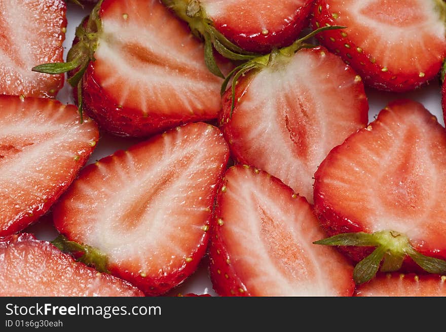 Strawberries cut into halves arranged as a background. Strawberries cut into halves arranged as a background