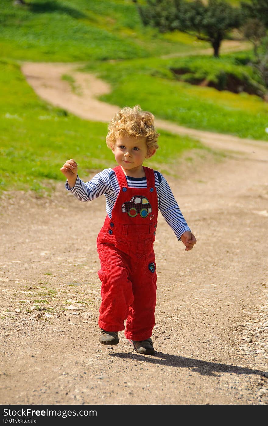 Little boy walking on a trail. Lots of green. Little boy walking on a trail. Lots of green.