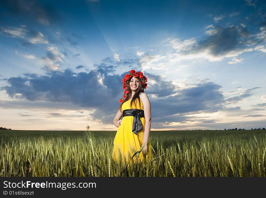 Beautiful Caucasian girl in floral wreath in the wheat field. Beautiful Caucasian girl in floral wreath in the wheat field